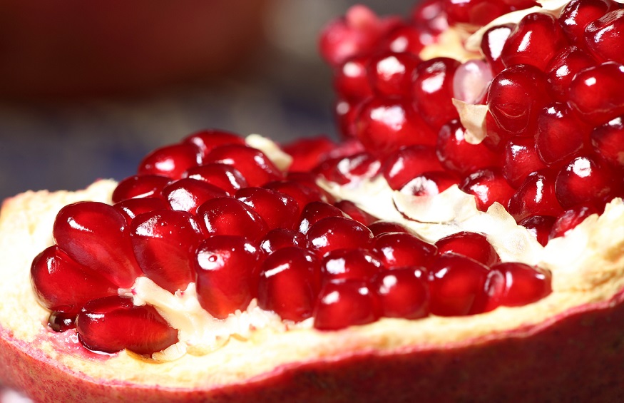 Ripe and juicy pomegranate broken into pieces, closeup